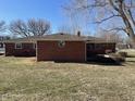 Backyard view of a brick home with a round window and grass, providing a sense of privacy at 2130 Theobald St, Shelbyville, IN 46176