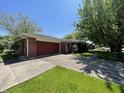Brick home with red garage door and mature landscaping; showcasing a well-kept exterior at 2130 Theobald St, Shelbyville, IN 46176