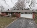 Traditional brick home with an attached garage and inviting porch swing, set in a serene neighborhood at 2210 Brewer Dr, Indianapolis, IN 46227