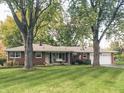 A charming single-story brick home with a well-manicured lawn and a welcoming front porch swing at 2210 Brewer Dr, Indianapolis, IN 46227