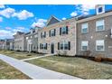 Attractive townhome showcases brick, manicured landscaping, dormer windows, and sidewalk at 2792 Maricopa Blvd, Whitestown, IN 46075