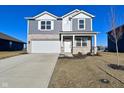 Charming two-story home featuring a stone facade, gray siding, well-manicured lawn, and a convenient two-car garage at 2976 W Tapestry Dr, Monrovia, IN 46157
