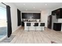 Modern kitchen with dark cabinets, a breakfast bar, stainless steel appliances, and bright lighting at 2976 W Tapestry Dr, Monrovia, IN 46157