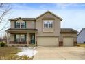 Charming two-story home featuring a covered front porch, three-car garage, and well-maintained landscaping at 307 Blue Spruce Dr, Pendleton, IN 46064