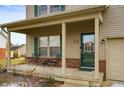 Welcoming front porch with chairs, decorative brick accents, and a charming entrance door at 307 Blue Spruce Dr, Pendleton, IN 46064