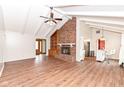 Inviting living room featuring a brick fireplace, vaulted ceilings, and hardwood floors at 406 Hickory Dr, Greenfield, IN 46140