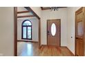 Inviting foyer featuring hardwood floors, wood trim, and a view of a large arched window at 4285 S Woodbridge Ln, New Palestine, IN 46163