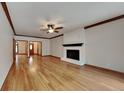 Spacious living room with hardwood floors, a white brick fireplace, and wood trim at 4285 S Woodbridge Ln, New Palestine, IN 46163