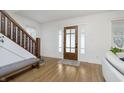 Bright foyer featuring hardwood floors, wooden staircase, and a beautiful front door at 4317 N Park Ave, Indianapolis, IN 46205