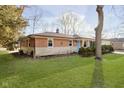 Brick ranch with a well-kept lawn showcasing mature trees and partial landscaping at 5201 Radnor Rd, Indianapolis, IN 46226