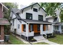 Charming two-story home with a front porch featuring wood accents and a manicured lawn at 633 E 32Nd St, Indianapolis, IN 46205