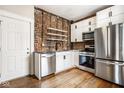 Modern kitchen featuring stainless steel appliances, white cabinetry, and exposed brick at 643 Fort Wayne Ave # B & D, Indianapolis, IN 46204