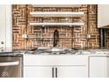 Bright kitchen detail featuring modern sink, shelving, and exposed brick wall at 643 Fort Wayne Ave # B & D, Indianapolis, IN 46204