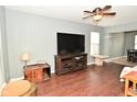 Open living room features hardwood floors, a ceiling fan, and contemporary decor at 6619 Captiva Pass, Plainfield, IN 46168