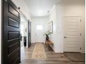 Bright foyer with sliding barn door, neutral walls, stylish rug, and wood-look flooring at 720 Keck Way, Westfield, IN 46074