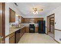 Functional kitchen featuring wood cabinets, black appliances, and plenty of counter space at 7579 Allenwood Ct, Indianapolis, IN 46268