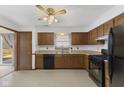 Well-lit kitchen with ample cabinet space, black appliances, and a view to the backyard at 7579 Allenwood Ct, Indianapolis, IN 46268