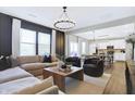 Inviting living room featuring a large sectional, modern lighting, and open floor plan at 8148 Ebaugh Dr, Camby, IN 46113