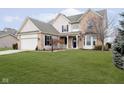 Beautiful two-story home with manicured lawn, brick and vinyl siding, an attached two car garage and a covered entryway at 8654 Arailia Dr, Plainfield, IN 46168