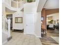 Spacious foyer featuring tile flooring, an open staircase, and views into the dining room and living room at 8654 Arailia Dr, Plainfield, IN 46168