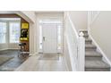 Welcoming foyer features tile flooring, a staircase with white railing, and a view of the front door at 8654 Arailia Dr, Plainfield, IN 46168