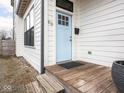 Close-up of a light blue front door with a classic design and a wooden porch at 910 Keystone Ave, Indianapolis, IN 46201