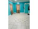 Turquoise living room featuring patterned tile flooring, two windows, and a turquoise door at 945 N Ewing St, Indianapolis, IN 46201