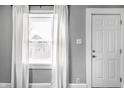 Bright interior view featuring a white door and window with white curtains at 1130 E Bradbury Ave, Indianapolis, IN 46203