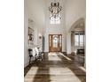 Bright foyer featuring hardwood floors, large windows, statement lighting and elegant staircase at 11573 Bent Tree Ct, Zionsville, IN 46077