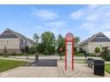 Scenic neighborhood view featuring condo-style homes, grassy areas, a cyclist, and a directory at 1208 Chapman Dr, Westfield, IN 46074