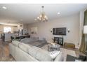 Open-concept living room with plush seating, modern lighting, and views of the dining area and kitchen at 1208 Chapman Dr, Westfield, IN 46074