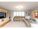 Bright living room with a large sectional sofa, built-in shelving, and hardwood floors at 12107 Castle Row Overlook, Carmel, IN 46033