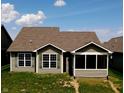 Rear view of a home with light gray siding, large windows, and a screened in porch at 1223 Blackthorne S Trl, Plainfield, IN 46168