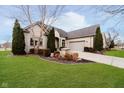 Beautiful cream brick home featuring three evergreen trees and manicured lawn at 14020 Quarter Horse Ct, Carmel, IN 46032