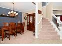 Elegant dining room featuring wooden table and chairs, chandelier, and staircase at 1905 Windsor Ln, Danville, IN 46122