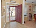 Inviting foyer with tile flooring, red front door, and view to front yard at 1905 Windsor Ln, Danville, IN 46122