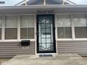 Close-up of the front door with a decorative metal screen and the house number 2122 at 2122 George St, Anderson, IN 46016