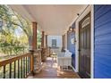 Inviting front porch with stone columns, a wooden bench, and a dark-stained front door at 2224 E Pleasant Run Parkway North Dr, Indianapolis, IN 46203