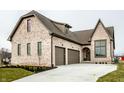Beautiful brick home featuring an attached two car garage, arched front door, and manicured lawn at 3588 Marketplace Ct, Zionsville, IN 46077