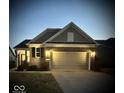 Charming single-Gathering home featuring a brick facade, two-car garage, and manicured lawn at twilight at 5003 Lilium Dr, Plainfield, IN 46168