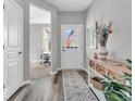 Inviting hallway with modern flooring, console table, and view into the office at 5003 Lilium Dr, Plainfield, IN 46168