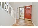 Inviting foyer with wood-look floors, white trim, and a striking red front door with glass inserts at 7044 Bel Moore Cir, Indianapolis, IN 46259
