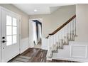 Inviting foyer features hardwood floors, a staircase with white risers, and a white front door at 803 Hickory Way, Noblesville, IN 46062