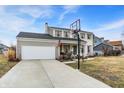 Charming two-story home features a brick facade, attached garage, and front porch with swing at 803 Hickory Way, Noblesville, IN 46062
