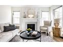 Sunlit living room featuring a fireplace with marble hearth, cozy armchair, and stylish decor at 105 N Irwin St, Indianapolis, IN 46219