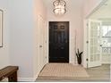 Inviting entryway features a black front door, modern lighting, and access to a bright office space at 1307 Peregrine Ln, Greenwood, IN 46143