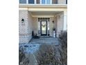 Charming front porch featuring brick columns, a decorative door, and a cozy seating area at 1347 Preserve Ct, Greenwood, IN 46143