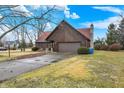 View of wood paneled home and yard, with driveway and chimney at 14304 Adios Pass, Carmel, IN 46032