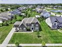 Aerial view of a well landscaped home in a community with mature trees, a playground, and a pond at 15694 Provincial Ln, Fishers, IN 46040