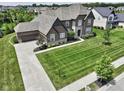 Stunning home with brick and stone exterior, a large manicured lawn, and an attached garage at 15694 Provincial Ln, Fishers, IN 46040